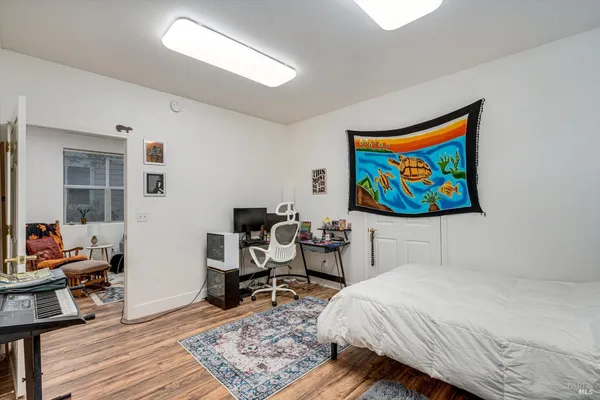 a bedroom with a bed and wooden floor