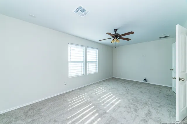 a view of a room with air conditioner and ceiling fan