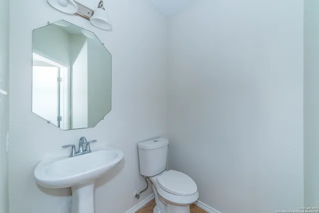 a bathroom with a toilet a sink and mirror