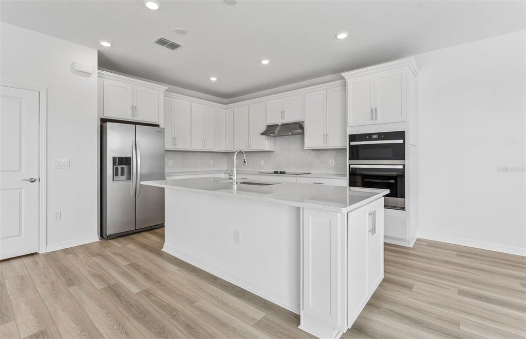 1691 Ruby Ln Lake Lake Alfred, FL 33850 - Photo 2 of 34 a kitchen with stainless steel appliances granite countertop a white stove top oven a refrigerator a sink and dishwasher with wooden floor