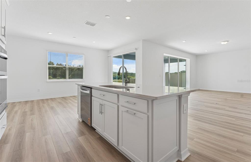 1691 Ruby Ln Lake Lake Alfred, FL 33850 - Photo 3 of 34 a kitchen with white cabinets and wooden floors