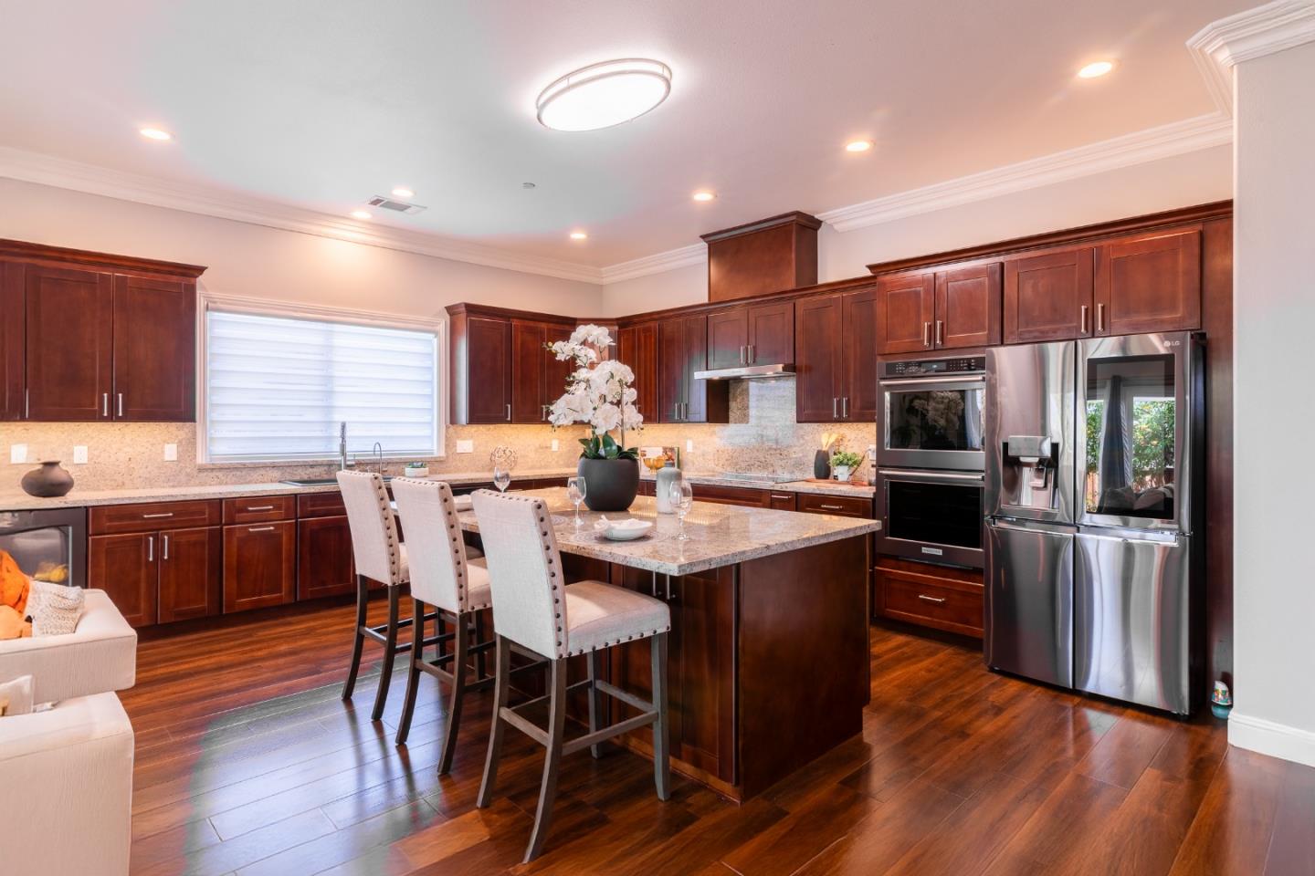 1258 South Stelling Road Cupertino, CA 95014 - Photo 11 of 56 a kitchen with stainless steel appliances kitchen island granite countertop a kitchen island a stove a refrigerator a sink a dining table and chairs