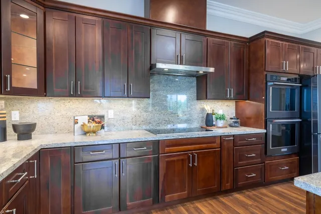 a kitchen with a dining table chairs and wooden floor