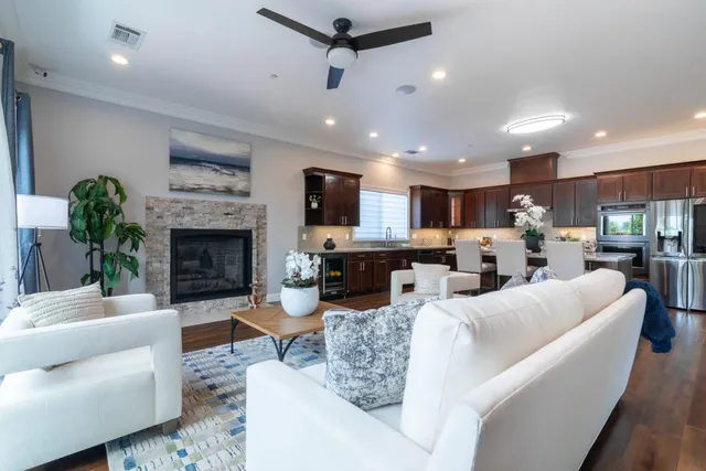 a living room with furniture a fireplace and a floor to ceiling window