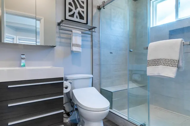 a living room with couches and kitchen view with wooden floor