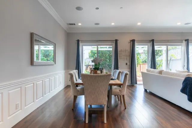 a kitchen with stainless steel appliances kitchen island granite countertop a kitchen island a stove a refrigerator a sink a dining table and chairs