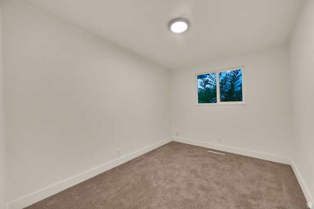 360 400 North Centerville, UT 84014 - Photo 19 of 30 Neutral-toned carpeting in a room with white walls, a single window, and a flush-mount ceiling light