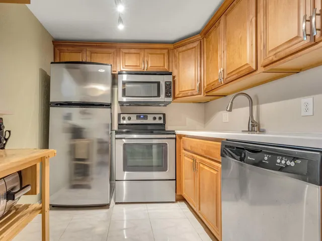 a kitchen with stainless steel appliances granite countertop a refrigerator and a stove top oven