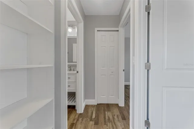 a view of a hallway with wooden floor and closet
