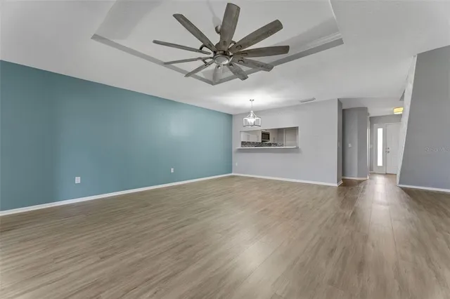 a view of a big room with wooden floor and a ceiling fan