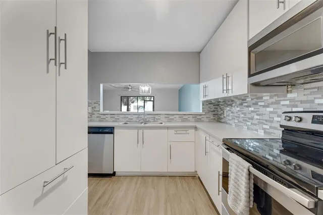 a kitchen with granite countertop a sink stove and cabinets