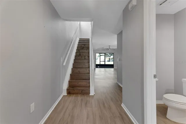 a view of a hallway with wooden floor and staircase