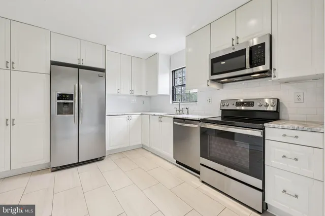 a kitchen with cabinets stainless steel appliances and counter space