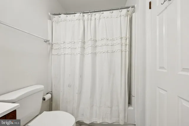 a white toilet sitting next to a shower curtain
