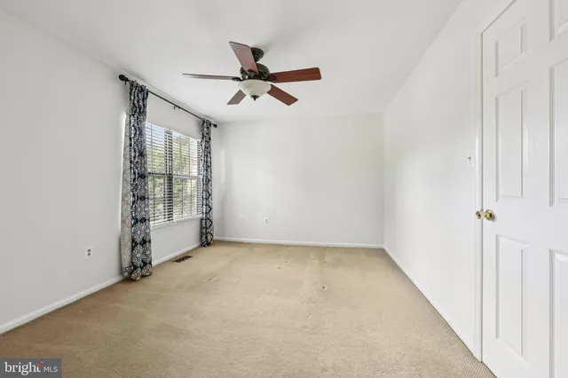 a view of a livingroom with a ceiling fan & entryway