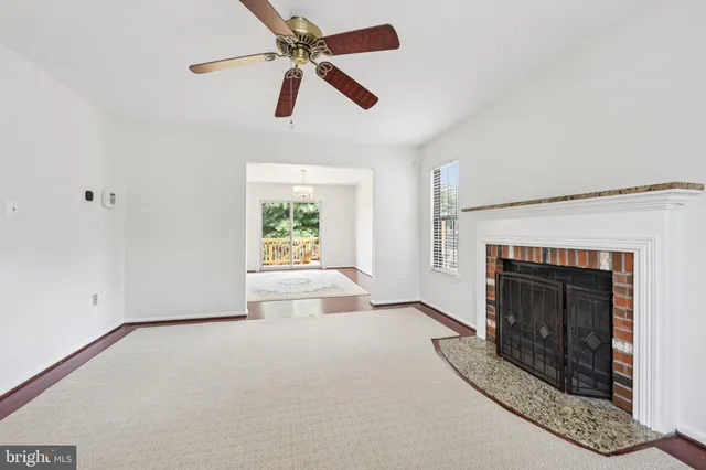 an empty room with windows and fireplace