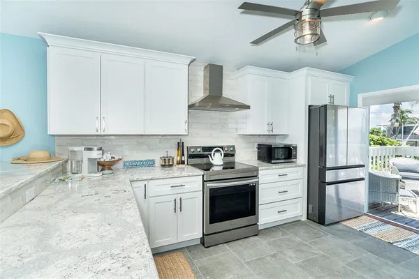 a kitchen with stainless steel appliances a stove a refrigerator and white cabinets