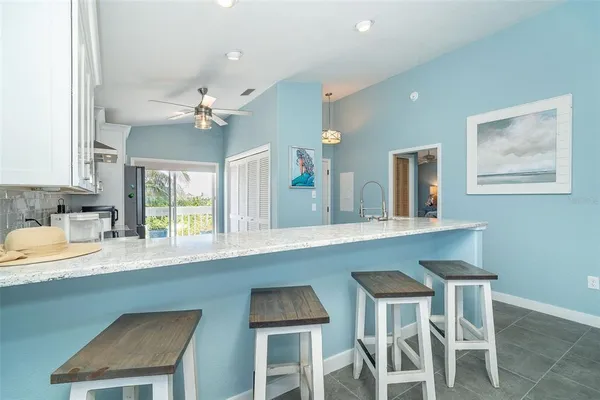 a kitchen with granite countertop white cabinets and chairs