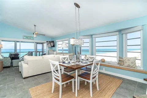 a dining room with furniture a chandelier and wooden floor