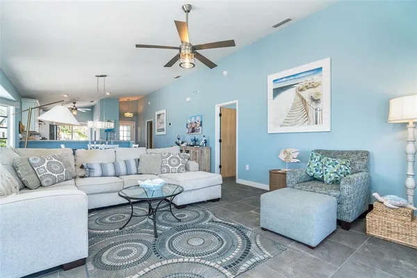 a living room with furniture and a view of kitchen