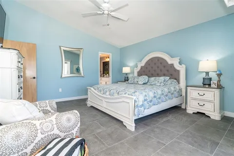 a bedroom with a large bed and a chandelier