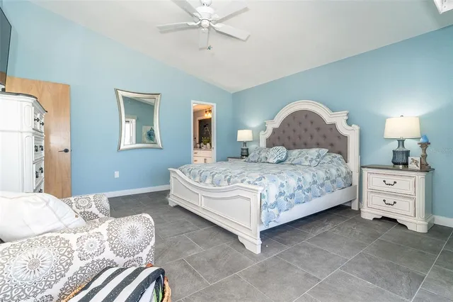 a bedroom with a large bed and a chandelier