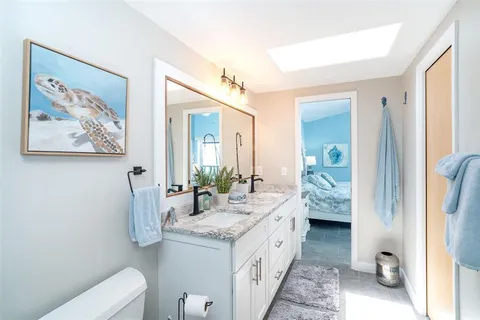a spacious bathroom with a granite countertop sink and a mirror