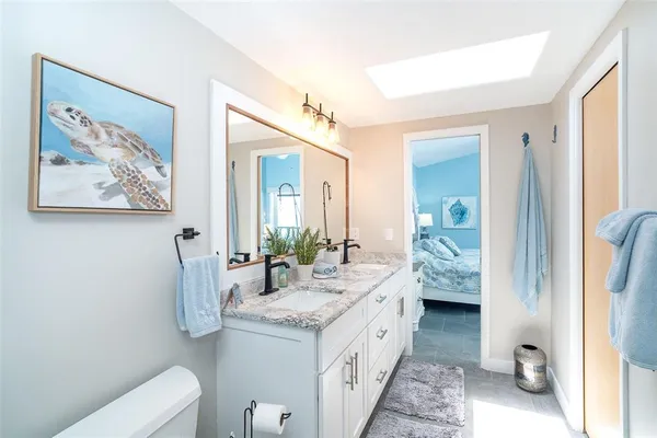 a spacious bathroom with a granite countertop sink and a mirror