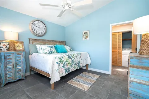 a bed sitting in a spacious bedroom next to a window