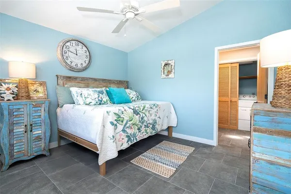 a bed sitting in a spacious bedroom next to a window
