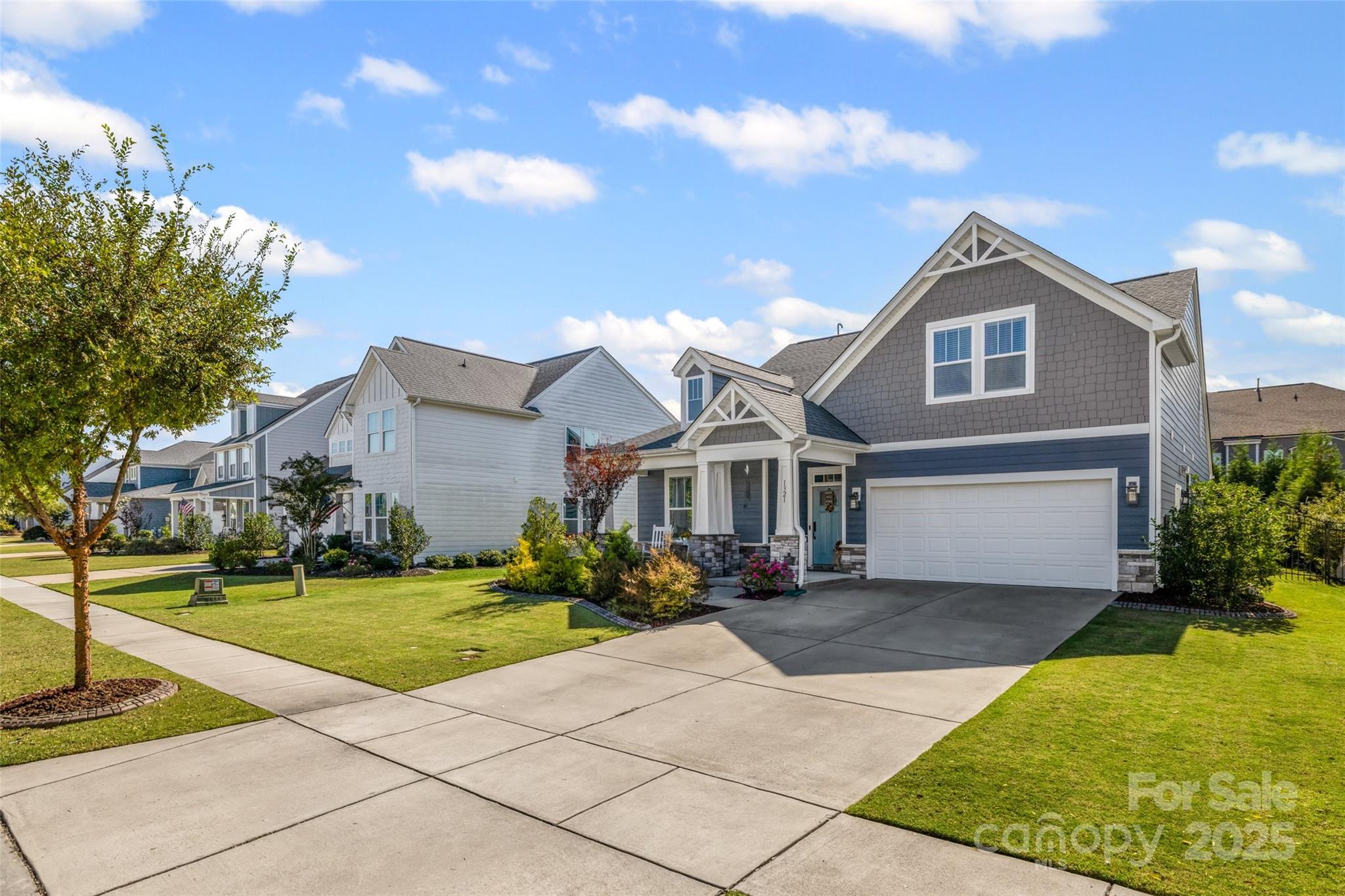 a front view of a house with a yard and trees
