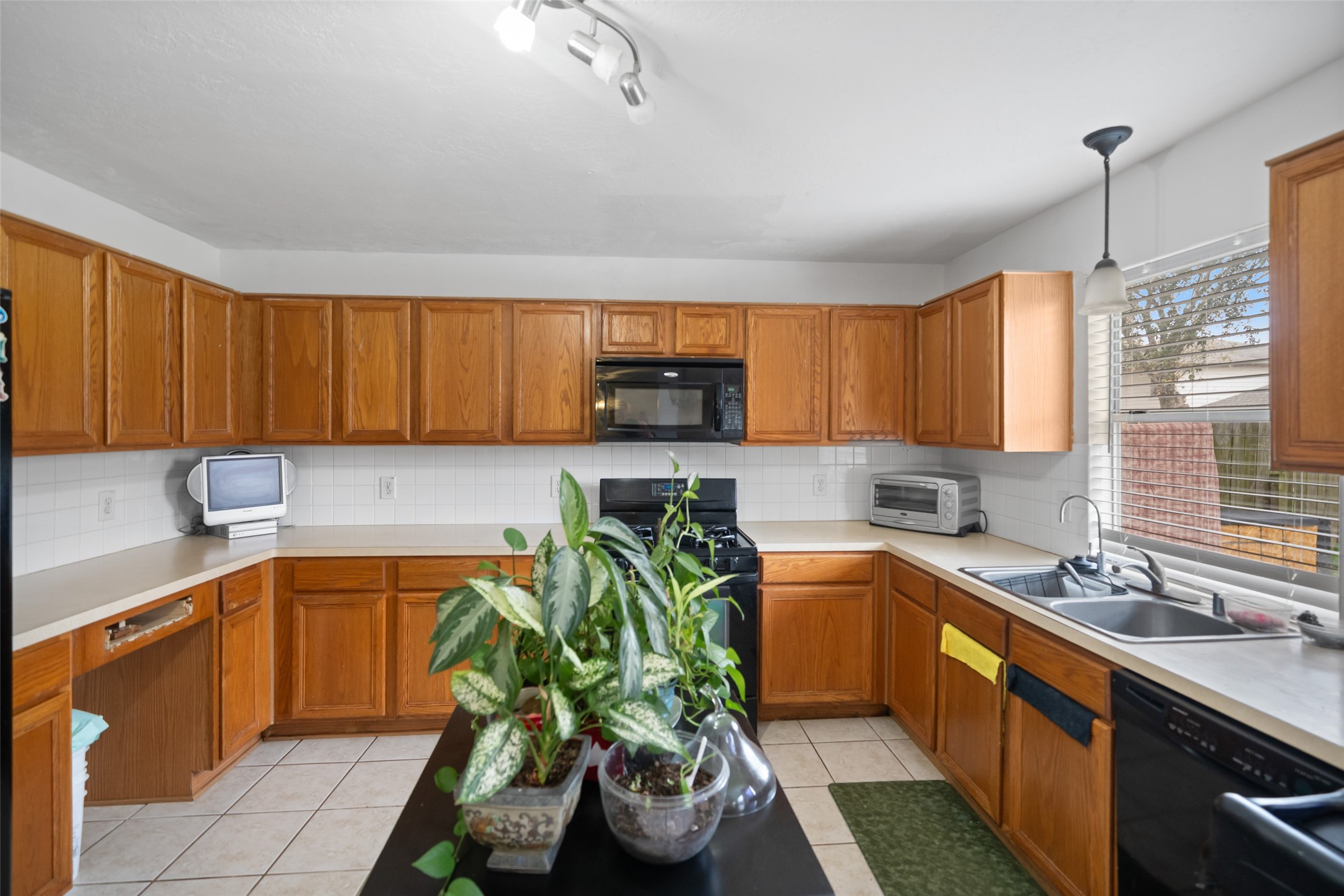 2514 Raintree Village Drive Katy, TX 77449 - Photo 3 of 26 a kitchen with a sink a counter top space appliances and cabinets