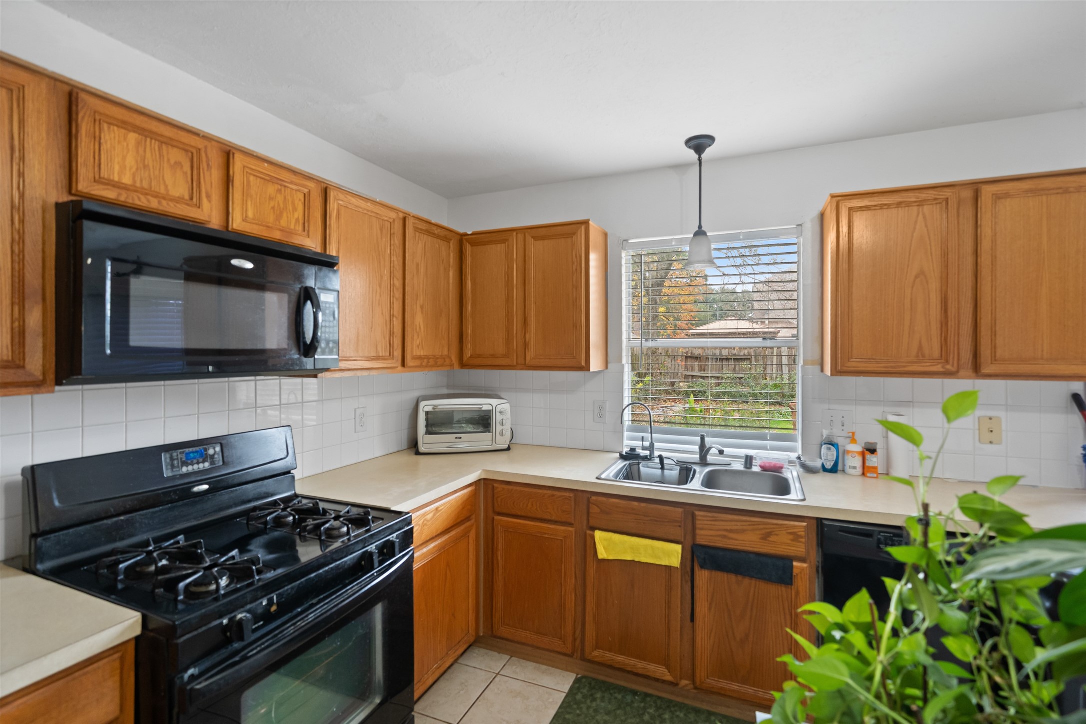 2514 Raintree Village Drive Katy, TX 77449 - Photo 10 of 26 a kitchen with granite countertop a stove a sink and a microwave