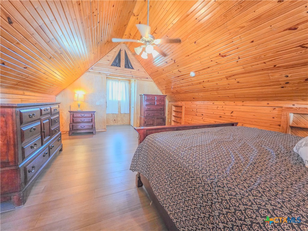 376 Haddock Drive Palacios, TX 77465 - Photo 24 of 41 This cozy bedroom features a charming wooden interior with a sloped ceiling and a ceiling fan. It includes two closet spaces for ample storage.