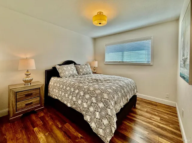 a bedroom with a bed and wooden floor