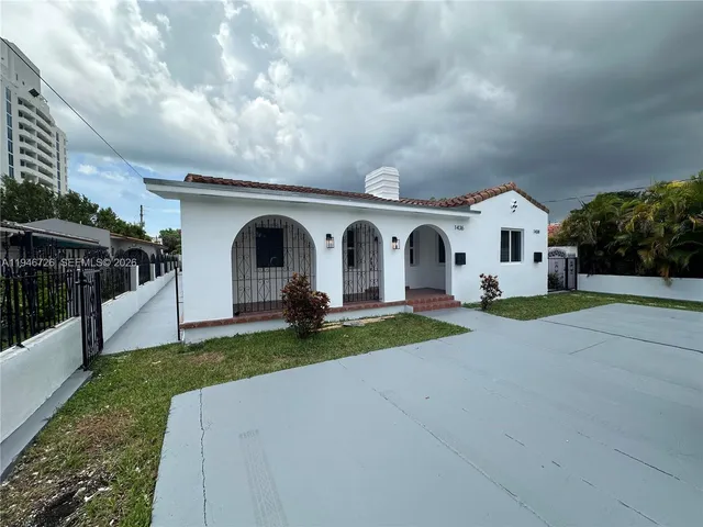 a view of house and garden with large trees