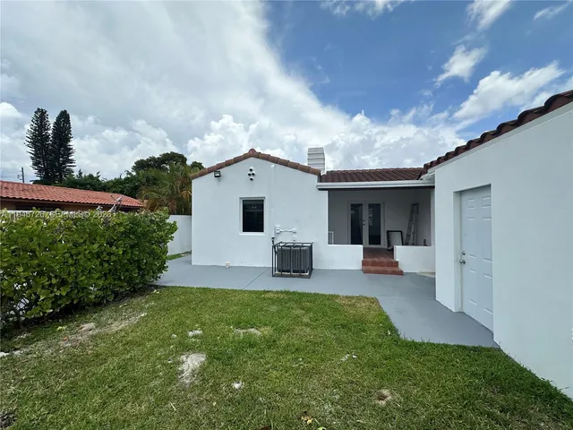 a view of a house with backyard and sitting area
