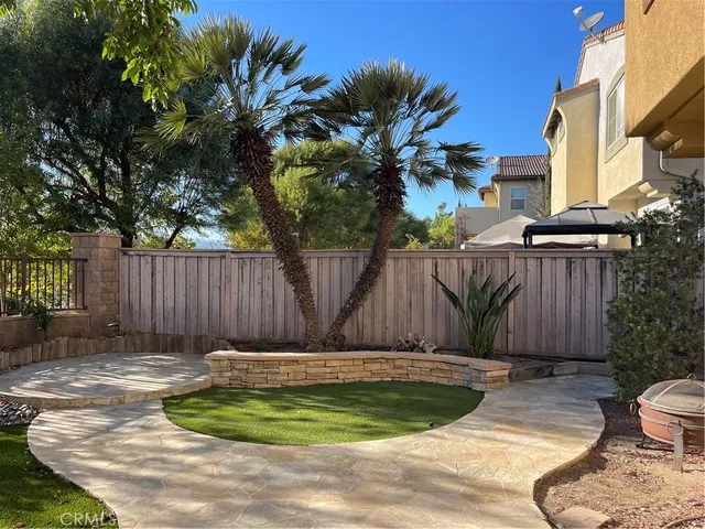 a view of a backyard with plants and large tree