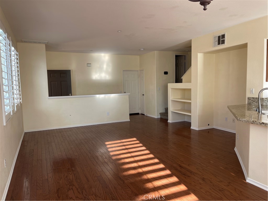 25248 Meadow Walk Street, Unit 1 Murrieta, CA 92562 - Photo 3 of 18 a view of kitchen and hall with wooden floor