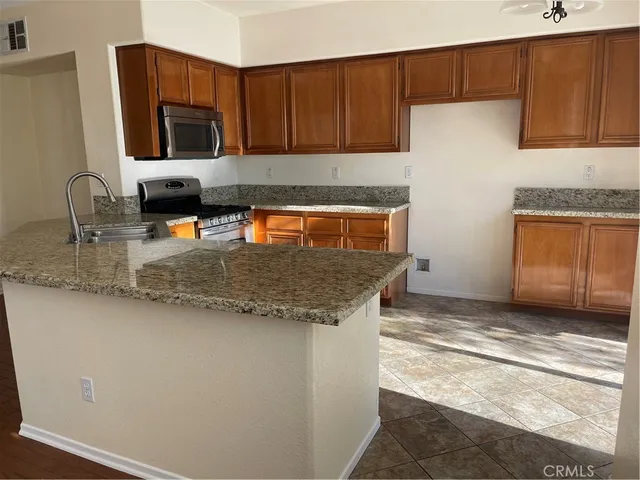 a kitchen with granite countertop a stove and a sink