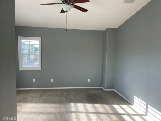a view of a room with a ceiling fan and window