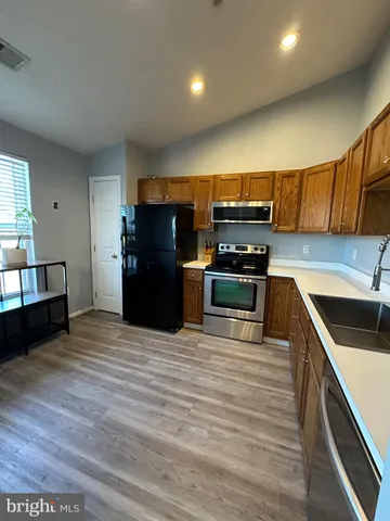 a kitchen with granite countertop a refrigerator and a stove top oven