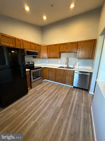 a kitchen with stainless steel appliances wooden cabinets a refrigerator and a stove