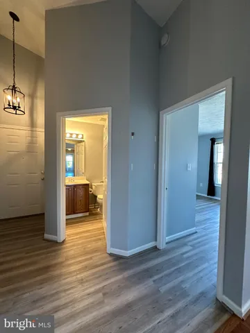a view of a room with wooden floor and a bathroom