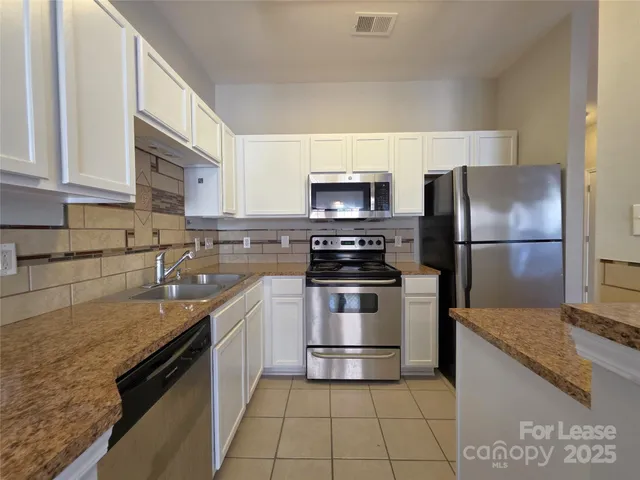 a kitchen with a sink a microwave and refrigerator