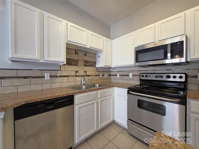 a kitchen with stainless steel appliances granite countertop a stove microwave and sink
