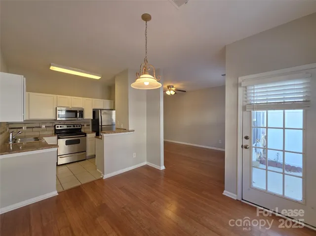 a kitchen with a refrigerator and white cabinets