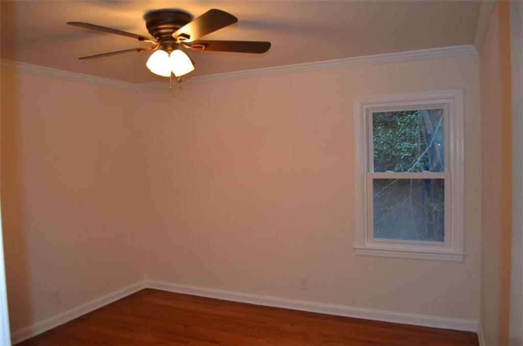 1329 Westridge Road Southwest Atlanta, GA 30311 - Photo 38 of 54 a view of an empty room with wooden floor and a window