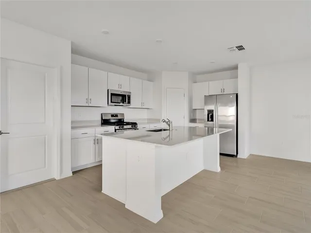 a kitchen with white cabinets and stainless steel appliances