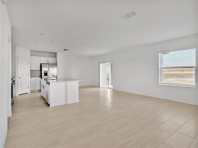 an empty room with a kitchen and a sink